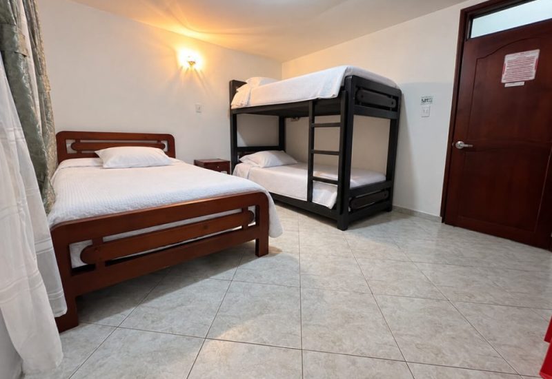 Habitación con cama doble y camarote junto a la puerta