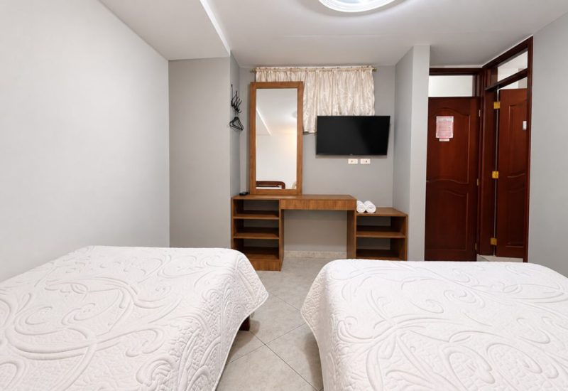 Habitación con dos camas y tocador con espejo