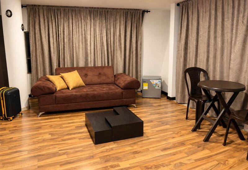 Sala con sofá marrón, mesa de centro y comedor