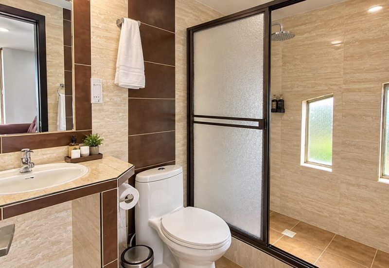 Baño con ducha de vidrio, lavamanos y ventana