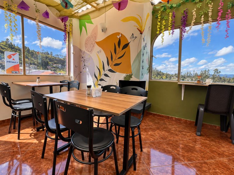 Cafetería con mesas y mural de colores