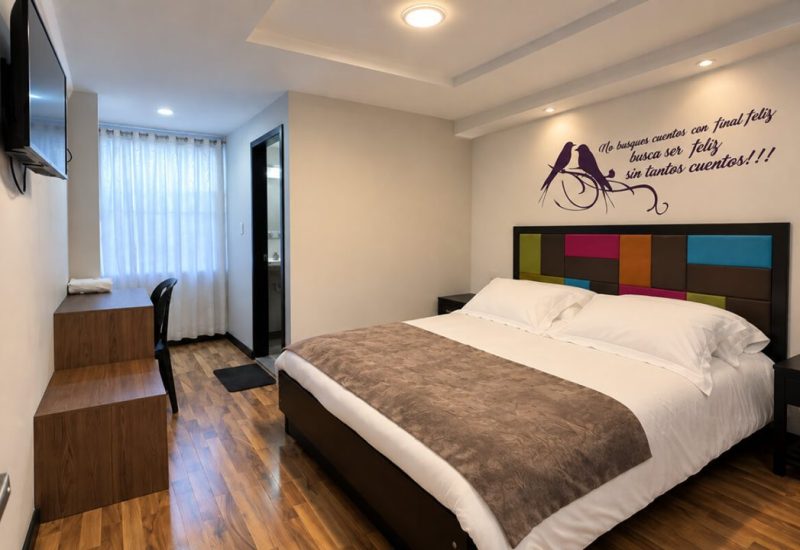 Habitación con cama doble, cabecero de colores y escritorio