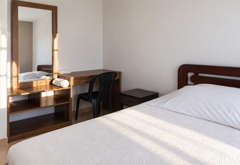 Habitación con cama doble, escritorio y espejo