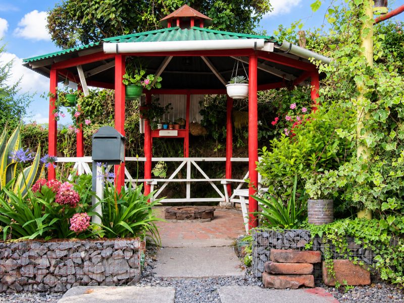 Kiosco rodeado de jardín con flores