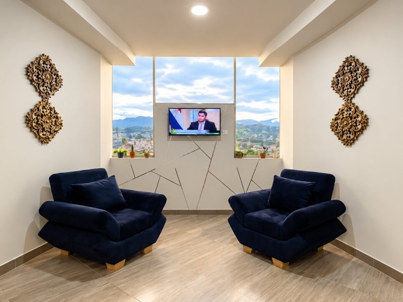 Sala de estar con dos sillones azules y televisor