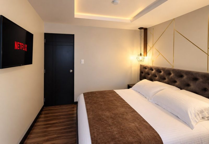 Cama con cabecero acolchado frente al televisor