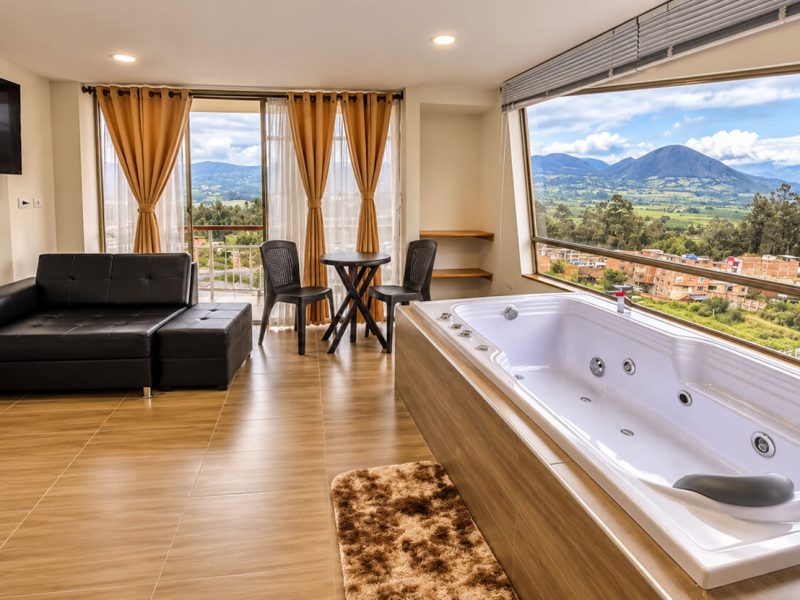 Suite con jacuzzi, sala y comedor frente a las montañas