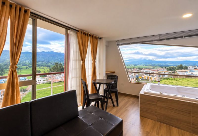 Suite con ventanales, sofá, comedor y jacuzzi