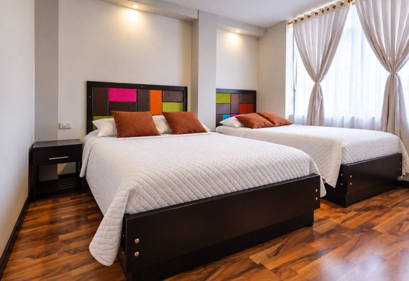 Habitación con dos camas y cabeceros de colores