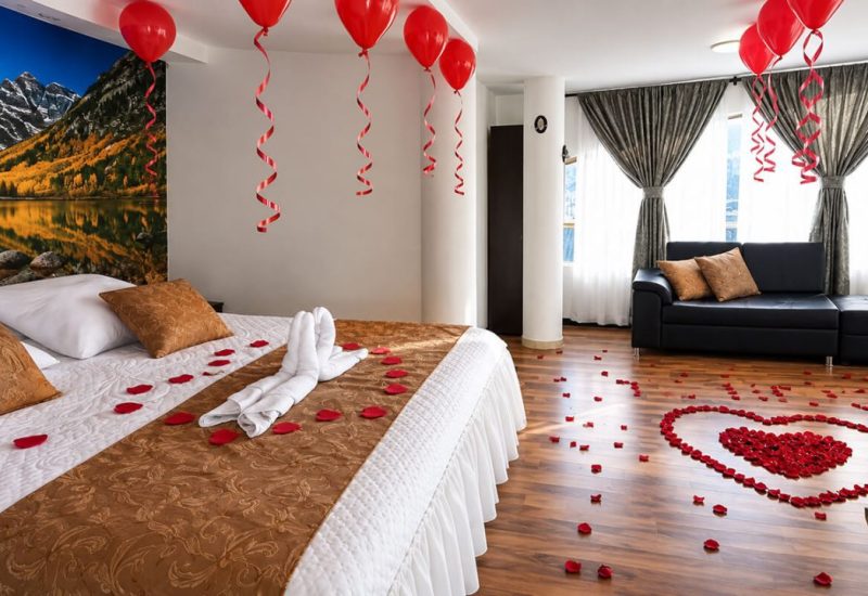 Suite decorada con globos rojos y pétalos de rosa