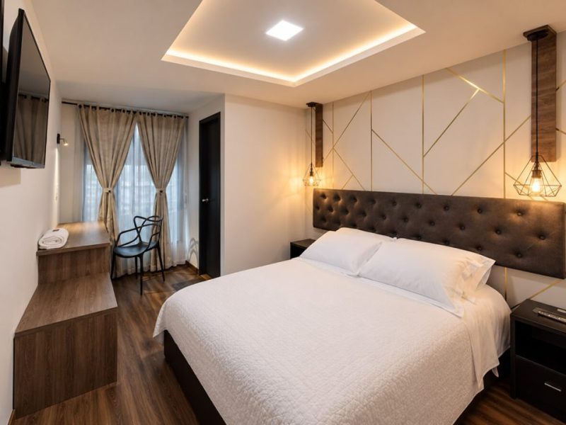 Habitación con cabecero acolchado, escritorio y lámparas colgantes