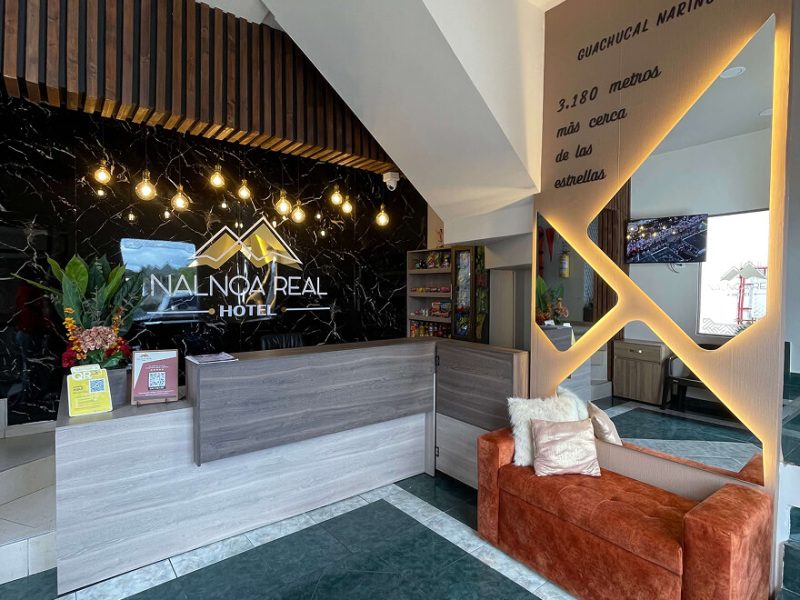Recepción del Hotel Nalnoa Real con letrero iluminado y sala de espera